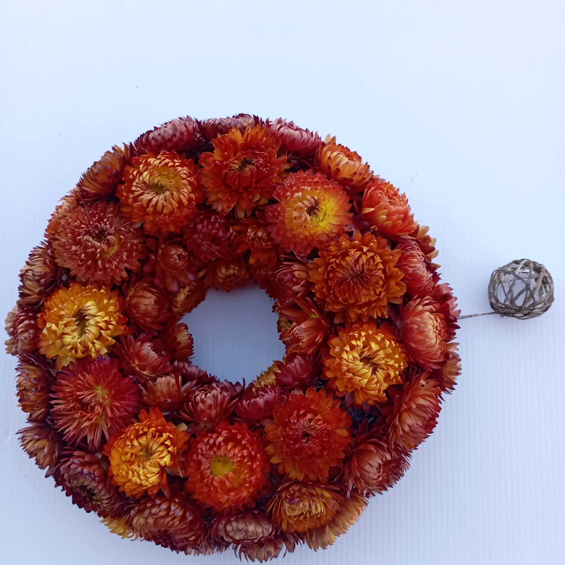 Couronne de deuil en immortelles séchées orange et rouge, vue d'ensemble, faite main